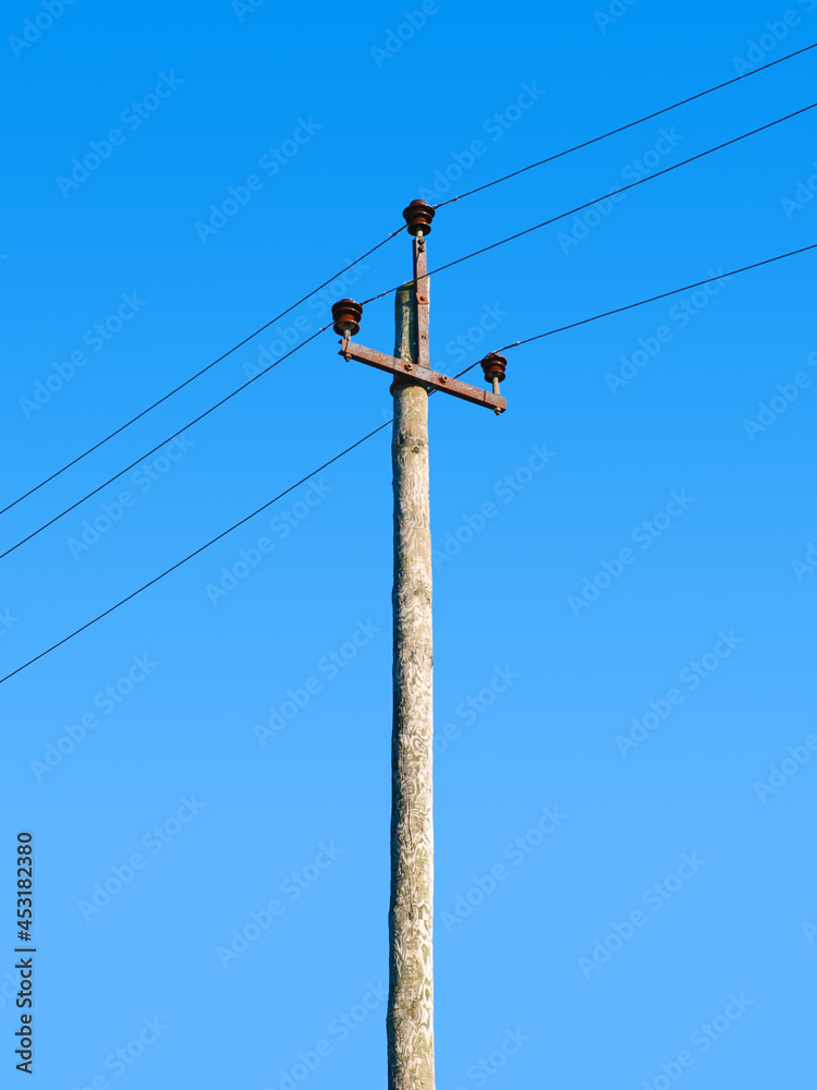 Old wooden power transmission pole with wires on a sky background Old wooden power transmission pole with wires on a sky background