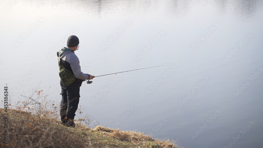 a man athletically dressed with a cane in his hand and a winter hat on his head. High-quality photo