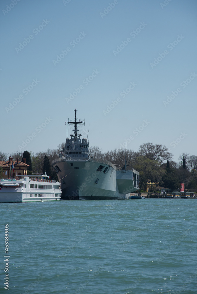 Obraz premium buildings, boats and the anchored military ship near canals in Venice,Italy, 2019