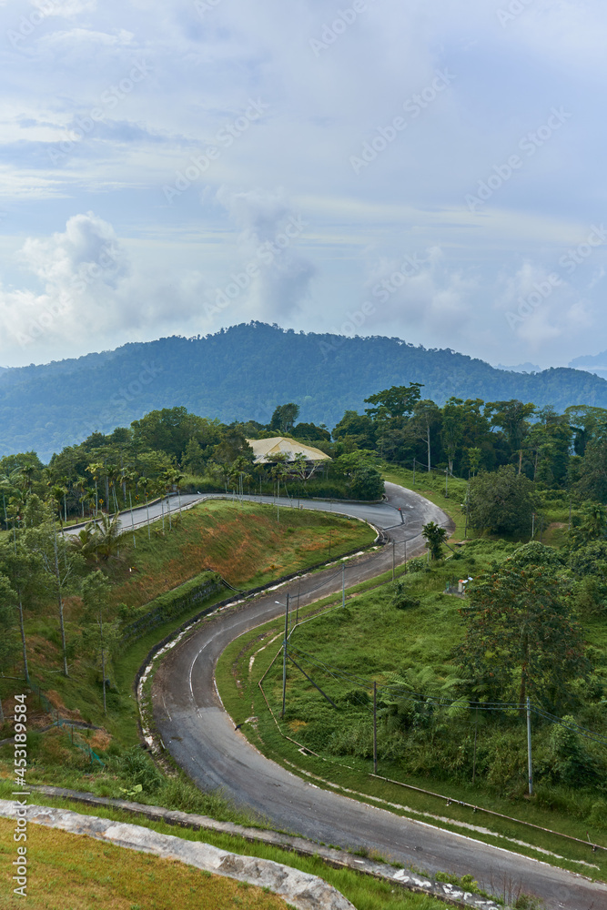 A view from a height on a mountain winding road in the tropical jungle