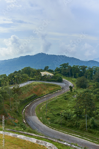 A view from a height on a mountain winding road in the tropical jungle
