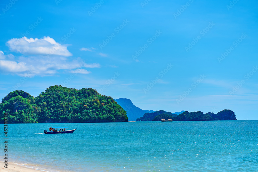 View from the beach to the rocks in the ocean away from the coast. Natural landscape of a tropical beach