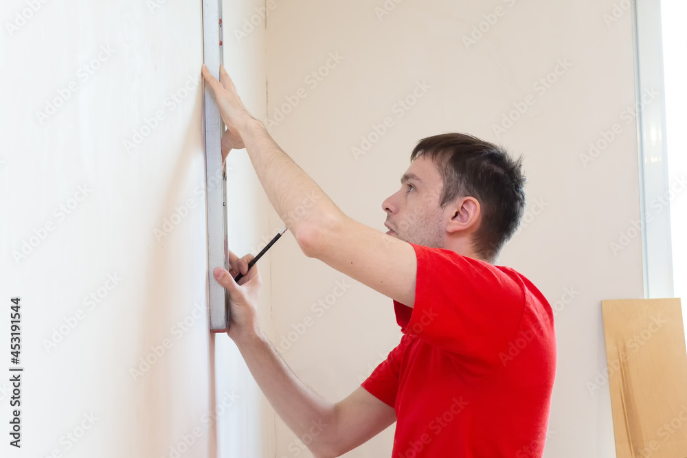 Man repair worker checking level of the wall with the bubble level tool. Renovation apartment concept. Man repair worker checking level of the wall with the bubble level tool. Renovation apartment concept.