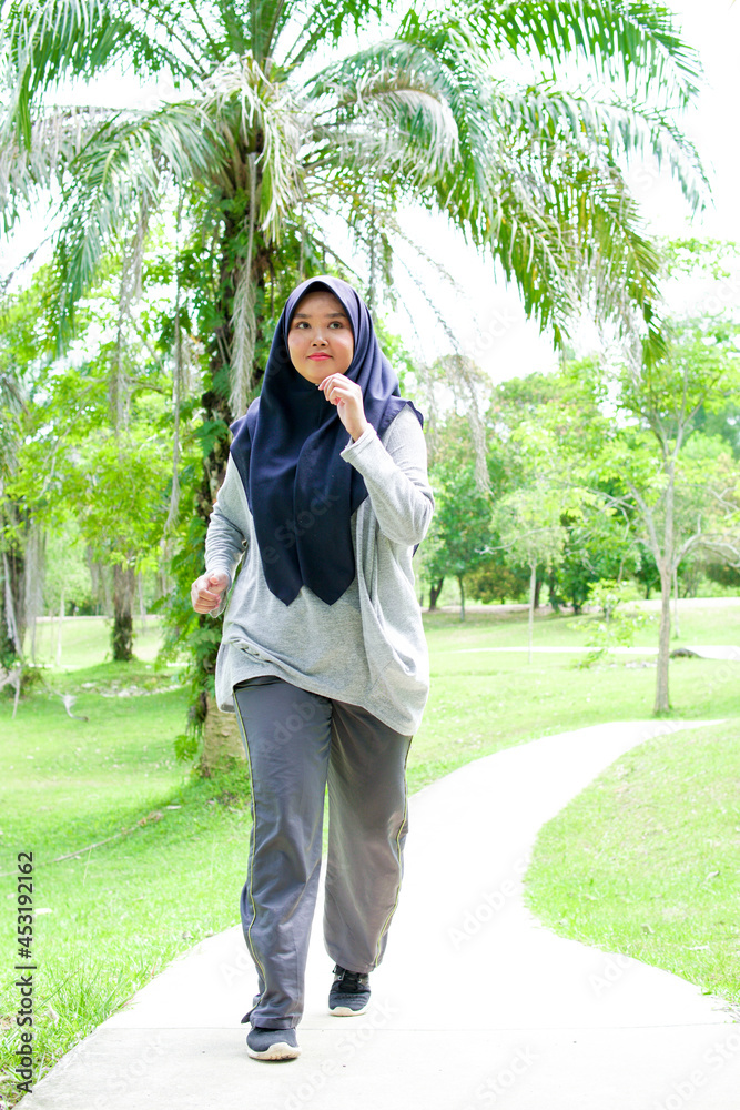 Portrait of a young muslim woman exercising and jogging outside in the park Portrait of a young muslim woman exercising and jogging outside in the park