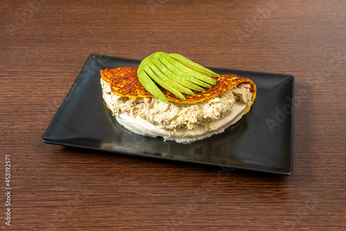 Venezuelan cachapa of reina pepiada, fresh cheese and half ripe chopped avocado photo