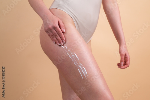 Body care. Woman applying cream on legs. Female applying anti cellulite cream. Cellulite or anti cellulite treatment. Body care and spa salon concept.