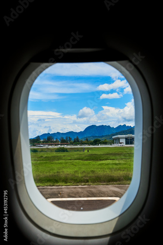 View from the window of an airplane on the runway of a tropical island