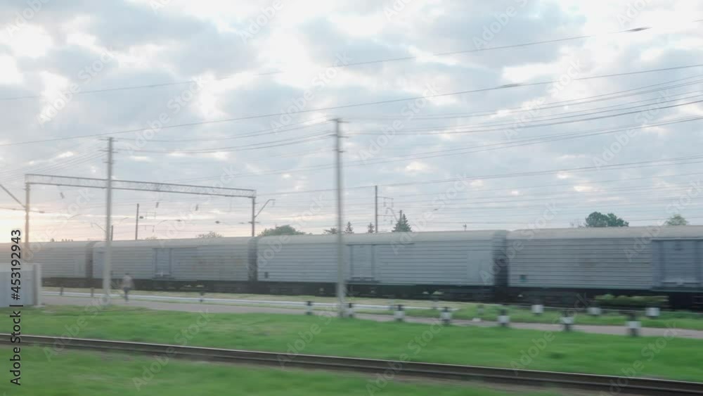 view from window of high-speed train on landscape of old rusty boxcars and high brick chimney on beautiful cloudy blue sky in summer background. Transport, travel, railway, road, comnication concept view from window of high-speed train on landscape of old rusty boxcars and high brick chimney on beautiful cloudy blue sky in summer background. Transport, travel, railway, road, comnication concept