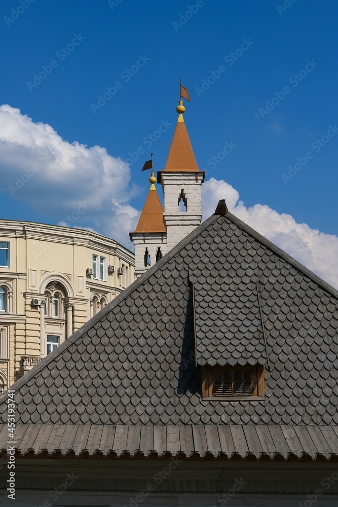 Close-up of ancient gray wooden tiled roof of historical stone building. Old wooden mosaic shingles on the roof. Example of mediavial wooden russian style architecture. Close-up of ancient gray wooden tiled roof of historical stone building. Old wooden mosaic shingles on the roof. Example of mediavial wooden russian style architecture.