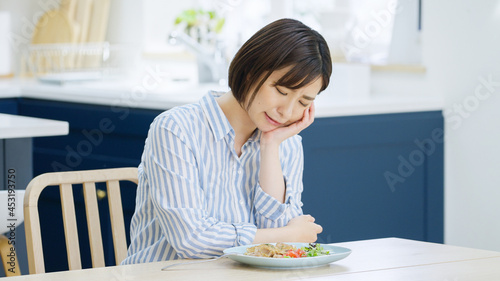 Cuadro en lienzo 食事中に考え事をする若い女性
