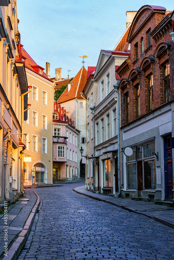 Narrow alley of medieval houses in the city of Tallinn at sunrise. Estonia.