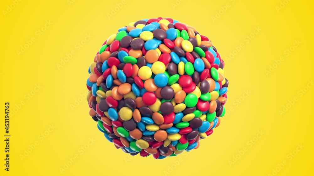 Colorful coated chocolate candies in the shape of a sphere rotate on yellow background. Seamless loop. Alpha layer is included. 3d rendering Colorful coated chocolate candies in the shape of a sphere rotate on yellow background. Seamless loop. Alpha layer is included. 3d rendering