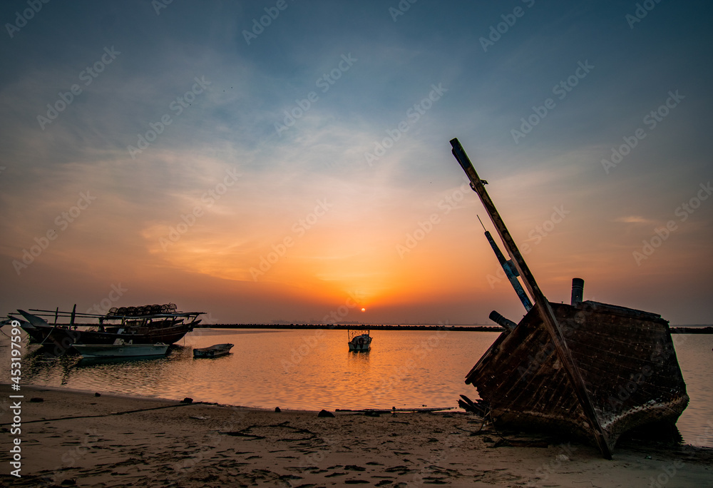 sunset on the beach with boats