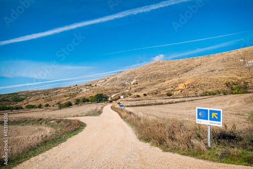 View of the Hill outside Castrojeriz with Way Marker Scallop Shell and Yellow Arrow Signs along the Pilgrim Way of St James Pilgrimage Trail Camino de Santiago photo