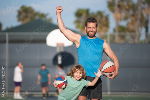 Father and son playing basketball. Excited family with a ball on the basketball court.