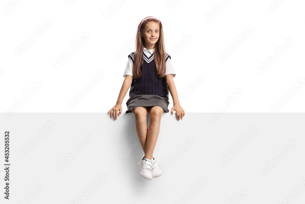 Beautiful young schoolgirl with long hair sitting on a blank panel Beautiful young schoolgirl with long hair sitting on a blank panel