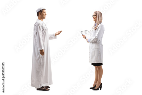 Full length profile shot of a young man in ethnic clothes talking to a female doctor