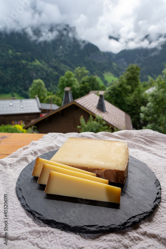 Cheese collection, French cow cheese comte, beaufort, abondance and french mountains village in Haute-Savoie on background photo