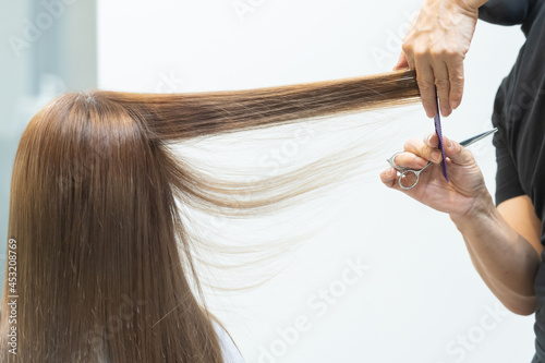 ヘアサロンで女性の髪の毛をカットするスタイリストの手元 photo