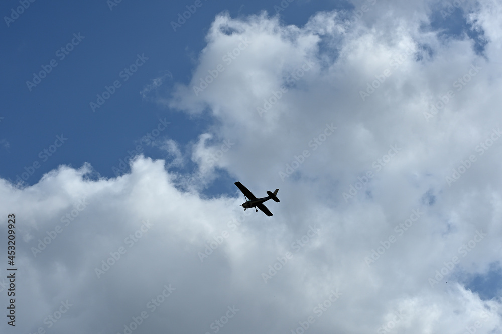 A silhouette of a Cessna plane flying against the blue sky. A silhouette of a Cessna plane flying against the blue sky.