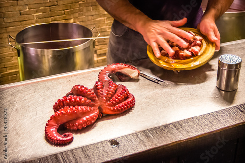 Famous Galician Style Boiled Squid Octopus Being Prepared in the Traditional Restaurant Pulperia Ezequiel in Melide, along the Way of St James Pilgrim Trail Camino de Santiago photo