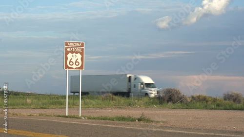 Semi trucks pass by on an interstate highway next to old Route 66 photo