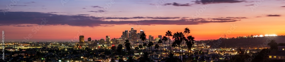 Fototapeta premium Panorama of Downtown Los Angeles at Sunset with Palm Trees and Clouds