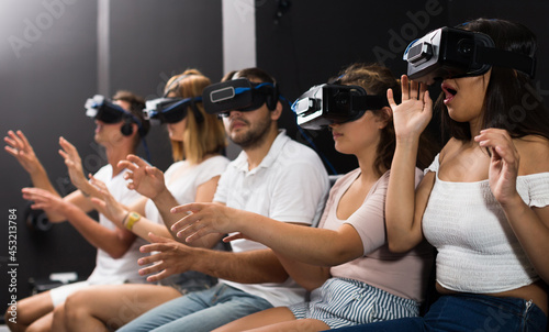 Young british scared girl on virtual reality attraction sitting with another people photo