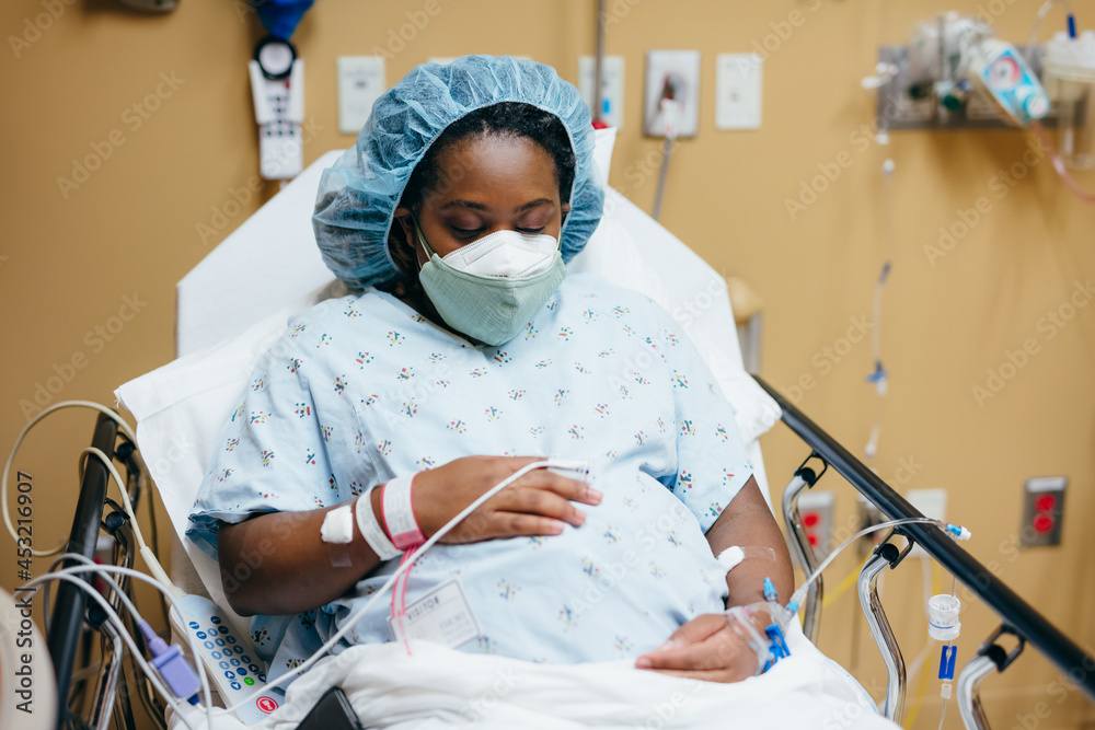 Woman wearing mask in hospital before giving birth, pregnant Stock