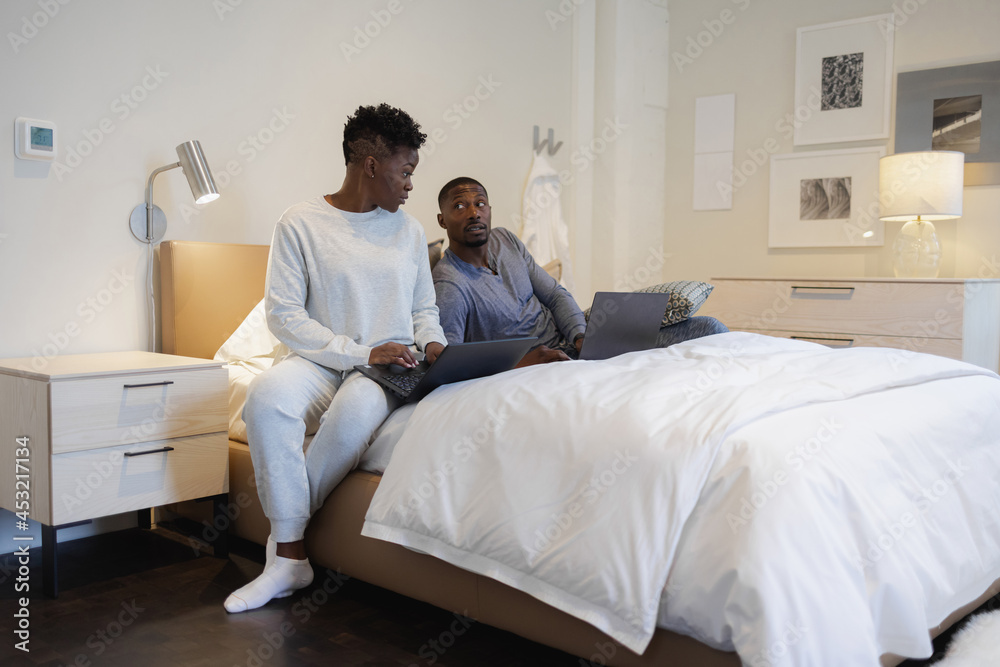 Couple using laptops in bed Couple using laptops in bed