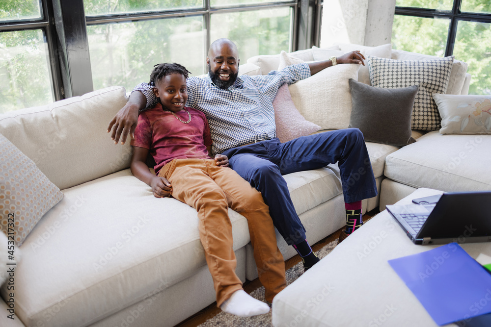 Smiling father and son sitting on sofa Smiling father and son sitting on sofa