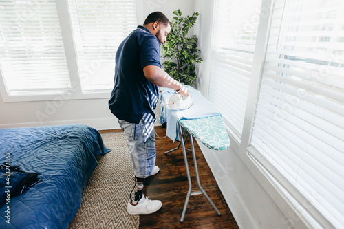 Black man ironing clothes, everyday life, disabled