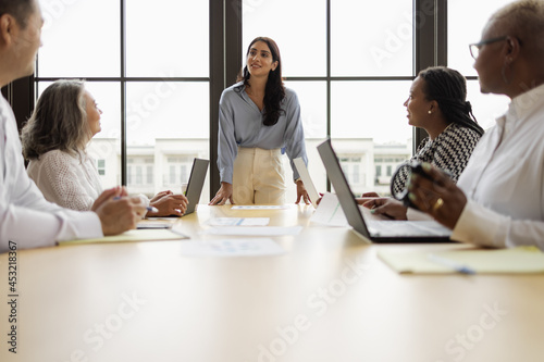 Mid Middle Eastern woman leading business team meeting