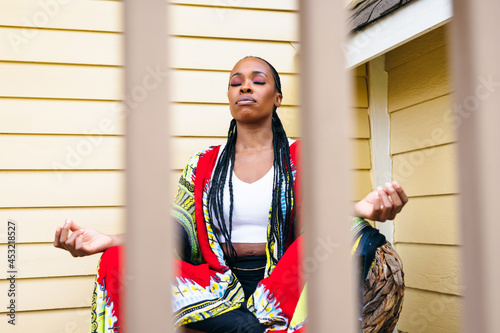 African american woman meditates at home outdoors photo
