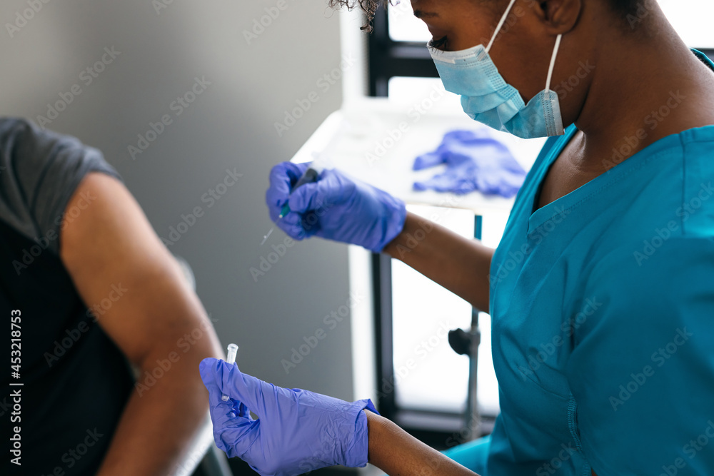 Black senior man gets vaccine, from nurse at doctors office Black senior man gets vaccine, from nurse at doctors office