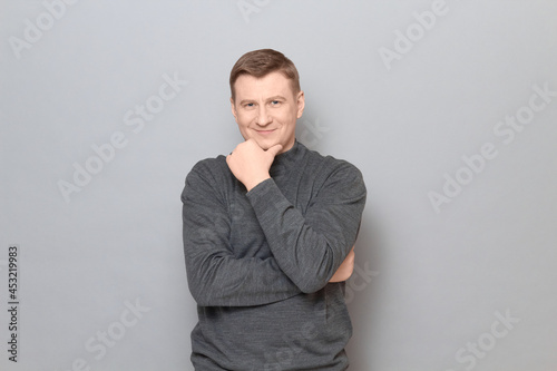 Portrait of happy mature man propping head with hand and smiling