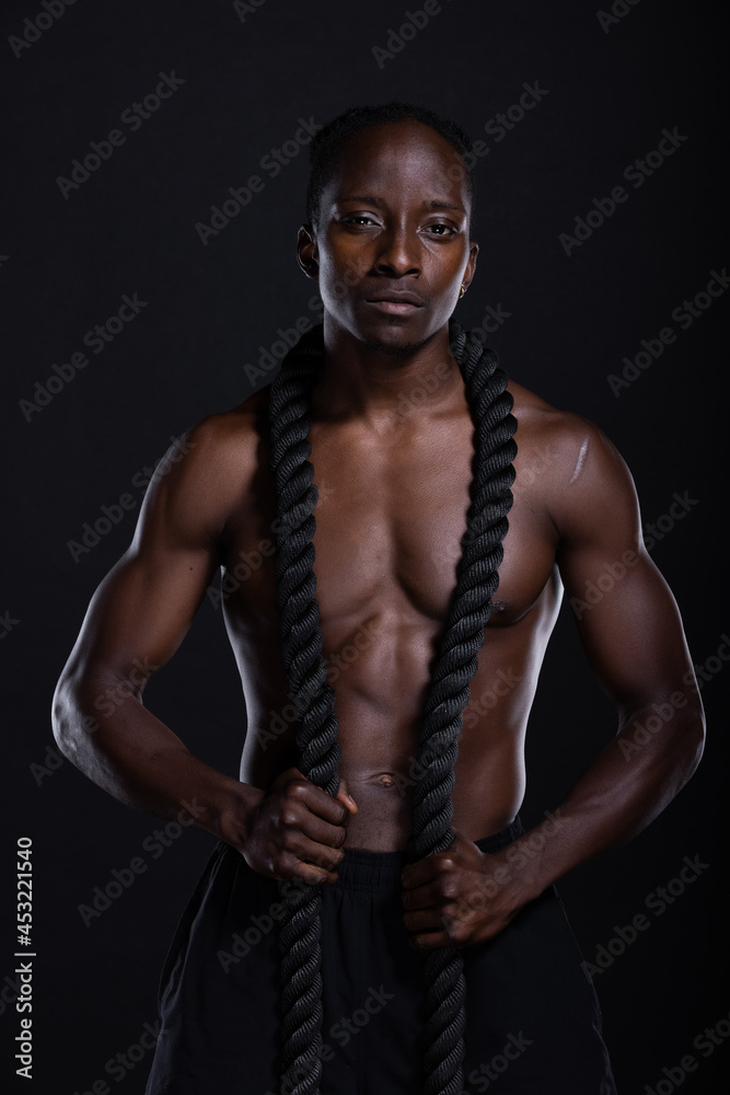 Fit African American man with muscles posing in studio Fit African American man with muscles posing in studio