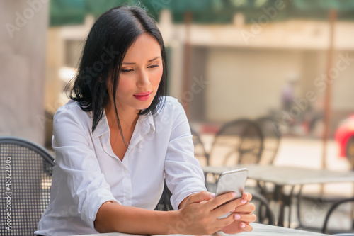 businesswoman or student at roadside coffee shop using smart phone