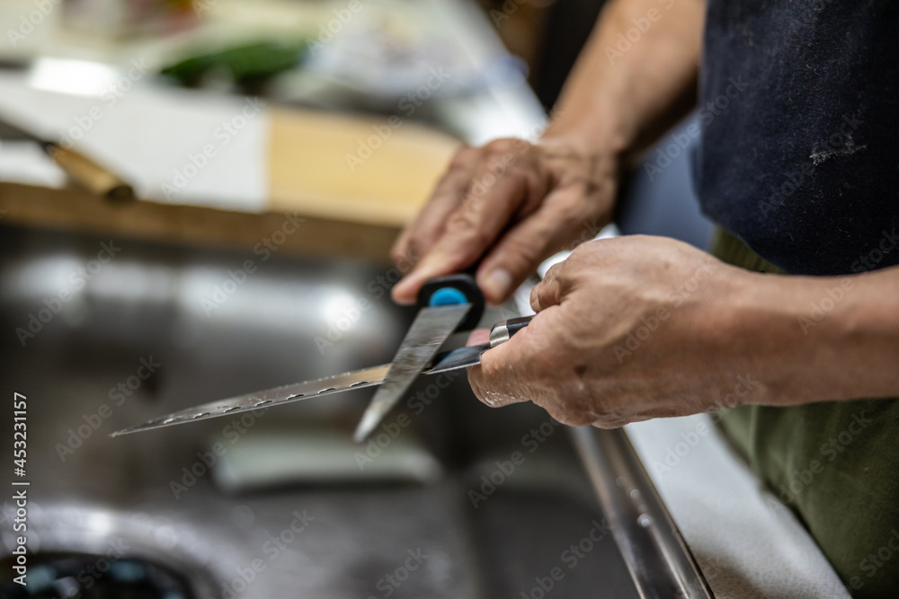 man's hand sharpening the knife in the kitchen man's hand sharpening the knife in the kitchen