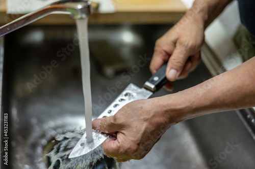 Man's hand washing the knife with water