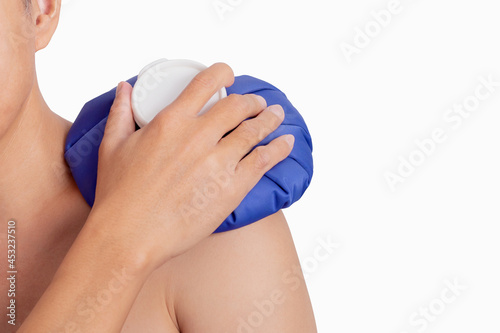 Man hand holding ice pack bag compress to the shoulder. Reduce pain and swelling photo