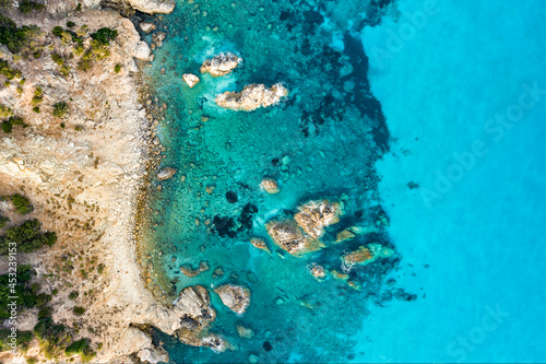 Fototapeta Naklejka Na Ścianę i Meble -  View from above, stunning aerial view of a green and rocky coastline bathed by a turquoise, crystal clear water. Costa Smeralda, Sardinia, Italy.