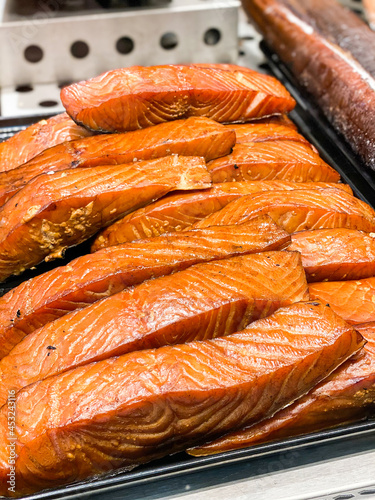 Smoked fillets of salmon for sale in delicatessen deli counter in market hall in sweden. Varmrökt lax.