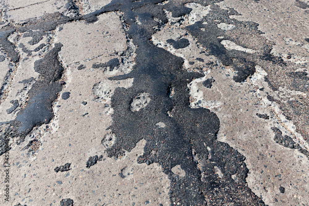 a bad asphalt road that has been repaired many times a bad asphalt road that has been repaired many times