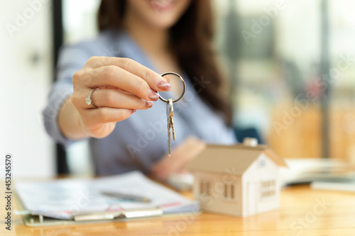 Female residential broker, real estate agent holding house keys