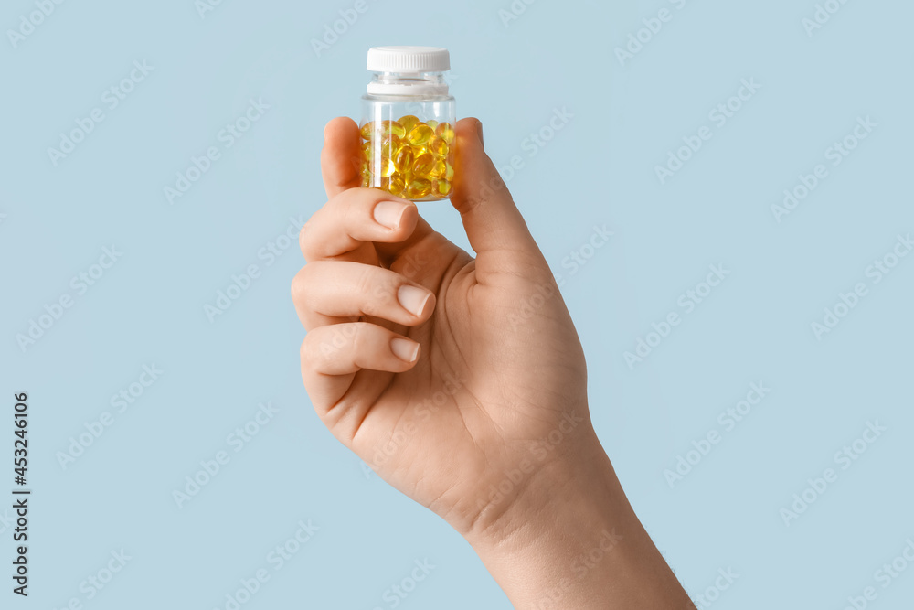 Female hand and bottle with pills on color background Female hand and bottle with pills on color background
