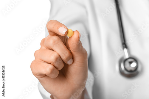 Female doctor with pill on white background