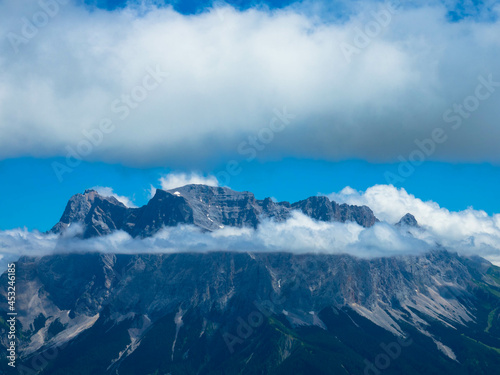 Tyrolean Zugspitze Arena. Panoramic aerial view at the Zugspitze mountain with a big cumulus cloud. The highest mountain in Germany. Seen from Lermoos village. Tourism and vacations concept.  © familie-eisenlohr.de