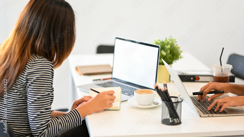 Female secretary checking mail on laptop, organising work, taking notes Female secretary checking mail on laptop, organising work, taking notes