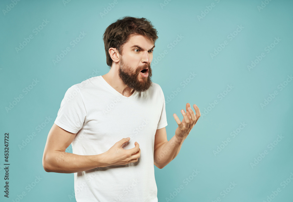 emotional man in a white t-shirt irritated facial expression blue background emotional man in a white t-shirt irritated facial expression blue background